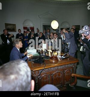 Fotografen und Filmkameramen Swarm Präsident John F. Kennedy an seinem Schreibtisch im Oval Office nach der Unterzeichnung des Cuba Quarantine Order. Stockfoto