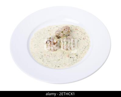 Fleischbällchen in weißer Sauce mit Kräutern. Isoliert auf weißem Hintergrund. Stockfoto