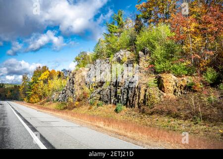 Faszinierende bunte verwinkelte Vermont Highway Straße gesäumt von Herbst Ahorn Bäume auf Felsen und Klippen lädt Reisende auf eine unvergessliche Reise auf Stockfoto