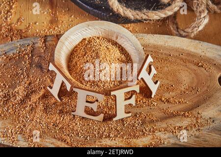 Teff, eine Alternative zum alten glutenfreien Korn mit dem Namen in Holzbuchstaben geschrieben. Teff hat sich zu einer beliebten Wahl für eine gesunde Ernährung Stockfoto