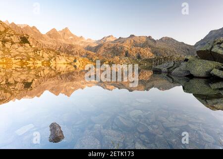 Berggipfel spiegeln sich im unberührten Wasser des Lago Nero di Cornisello, Naturpark Adamello Brenta, Trentino-Südtirol, Italien Stockfoto