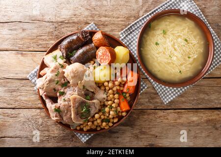 Cocido ist ein traditionelles Kichererbsen-Eintopf mit Huhn, Rindfleisch, Blutwurst, Chorizo und Schweinebauch Nahaufnahme auf einem Teller auf dem Tisch. Horizontal oben Stockfoto