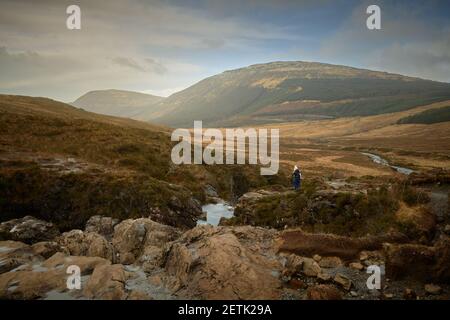 Bergsteiger Tourist Blick auf atemberaubende Aussichten in bergigen Tal.Konzept Reise, Tourismus Fairy Pools Skye Island - Schottland Stockfoto