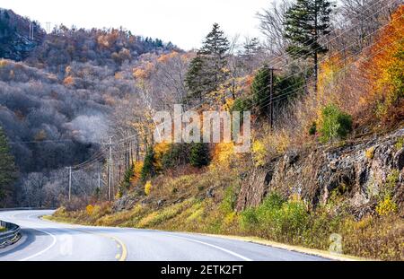 Faszinierende bunte verwinkelte Vermont Highway Straße gesäumt von Herbst Ahorn Bäume auf Felsen und Klippen lädt Reisende auf eine unvergessliche Reise auf Stockfoto