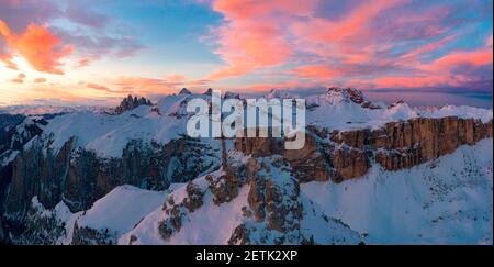 Rosafarbene Wolken bei Sonnenuntergang über Gran Cir Gipfelkreuz und Geislerberge im Winter mit Schnee bedeckt, Dolomiten, Südtirol, Italien Stockfoto