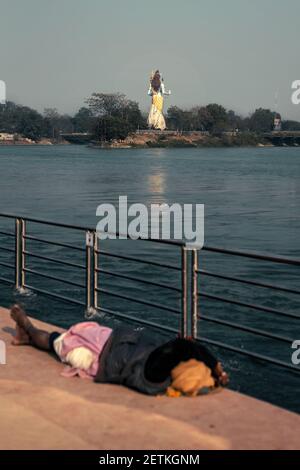 Statue von Herrn Shiva Mahadeva in der Nähe Ganga Fluss in Haridwar Mit einer einzigen Person mit verborgenem Gesicht schlafen auf der Füße Gottes Stockfoto