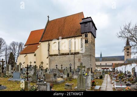 Milevsko, Tschechische Republik - Februar 27 2021: Blick auf die mittelalterliche römisch-katholische Kirche St. Giles, die in der Mitte des Friedhofs steht. Kloster Stockfoto