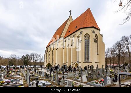 Milevsko, Tschechische Republik - Februar 27 2021: Blick auf die mittelalterliche römisch-katholische Kirche St. Giles, die in der Mitte eines Friedhofs steht. Wintertag Stockfoto