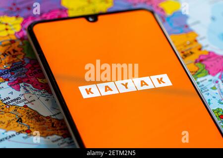 Vilnius, Litauen - März 2 2020: Nahaufnahme der Reisebüro-App Kayak, Symbole, Logo auf einem Smartphone mit einer geografischen Karte im Hintergrund Stockfoto