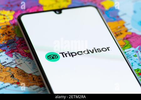 Vilnius, Litauen - März 2 2020: Nahaufnahme der Reisebüro-App Tripadvisor, Symbole, Logo auf einem Smartphone mit einer geografischen Karte auf der Rückseite angezeigt Stockfoto