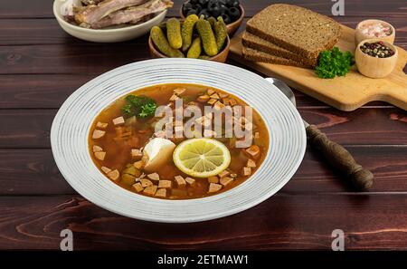 Der Teller mit der russischen oder osteuropäischen traditionellen Suppe soljanka oder soljanka vom Tisch. Hausgemachte Küche. Stockfoto