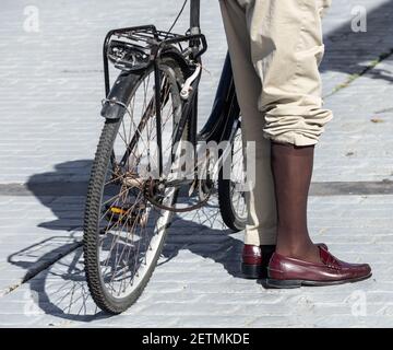 Elegant gekleideter älterer Mann, der Fahrrad fährt. Stockfoto