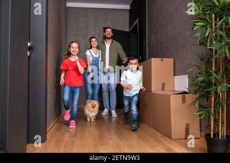 Mama und Papa mit ihrem Sohn und ihrer Tochter im Flur der neuen tierfreundlichen Wohnung, nur in den Umzug Stockfoto
