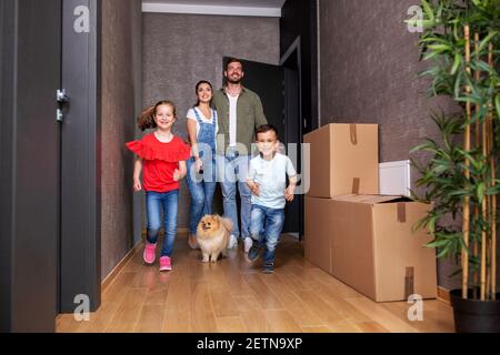 Mama und Papa mit ihrem Sohn und ihrer Tochter im Flur der neuen tierfreundlichen Wohnung, nur in den Umzug Stockfoto