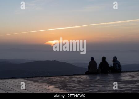 Touristen beobachten einen erstaunlichen Sonnenaufgang von der Spitze des Berges La Mola im Parc Natural de Sant Llorenc del Munt i l'Obac, Valles Occidental, Catalo Stockfoto