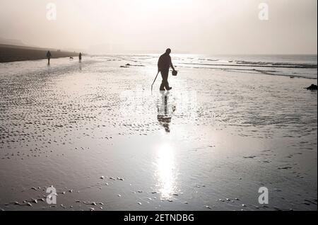 Brighton UK 2nd March 2021 - EIN Köder-Bagger im Nebel am Strand von Brighton früh am Morgen, als er das Beste aus einer zusätzlichen Ebbe entlang der Sussex Küste macht. Das Wetter wird prognostiziert, um warm und sonnig nach dem frühen Nebel wird erwartet, dass von der Sonne verbrannt werden : Credit Simon Dack / Alamy Live News Stockfoto