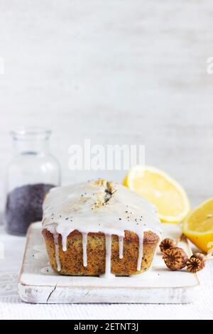 Zitronenkuchen mit Mohnsamen, bedeckt mit Glasur auf hellem Hintergrund. Stockfoto