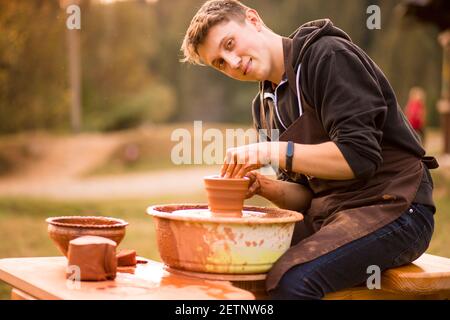 Man Töpfer arbeiten mit Tonwaren. Junger hübscher Mann Töpfer auf seiner Werkstatt. Stockfoto