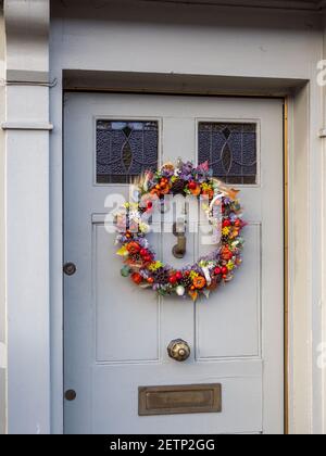 Farbenfroher Weihnachtskranz an einer Haustür in der Marktstadt Olney, Buckinghamshire, Großbritannien Stockfoto