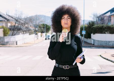 Weibliche Fernsehreporterin Journalistin mit afro Haar Berichterstattung über ein news Geschichte auf der Straße Stockfoto