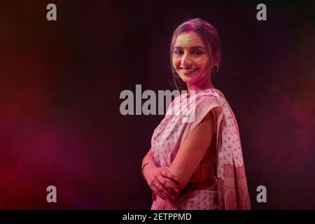 PORTRÄT EINER JUNGEN FRAU MIT GULAL ÜBERALL TRAGEN SAREE UND BLICK AUF DIE KAMERA Stockfoto