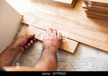 Montage von gemusterter Holzoberfläche auf einem stabilen Gemisch Unterboden Leim Stockfoto