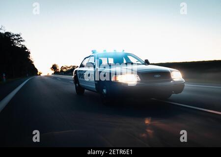 FORT MYERS, USA - 01. Feb 2021: Ein Foto eines amerikanischen Polizeiautos, das auf der Straße fährt. Verkehrsmittel in schneller Aktion bei Nacht. Stockfoto