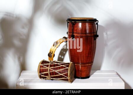 Komposition des musikalischen ethnischen Instruments. Maracas, Tamburin, Conga und ethnische Trommel. Percussion Rhythm Instrumente sind auf weißem Hintergrund mit Handflächen Stockfoto