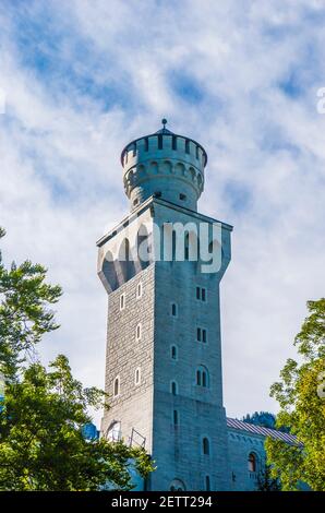 neuschwanstein, berühmtes Schloss der Märchen, Prinzessinnen und Liebenden, sticht vor dem blauen Himmel und den Wäldern vor der Kulisse der Seen hervor Stockfoto