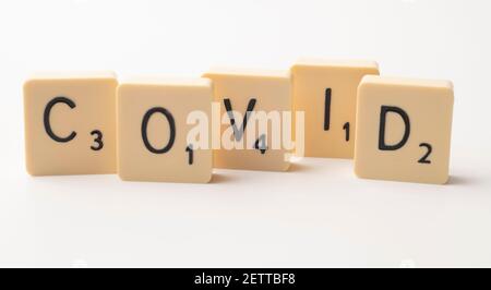 Coronavirus Pandemie themed scrabble Spiel Wort Fliesen auf einem weißen Hintergrund Stockfoto