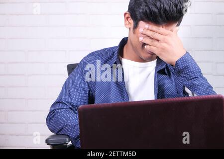 Nahaufnahme eines traurigen Mannes, der das Gesicht mit der Hand bedeckt. Stockfoto