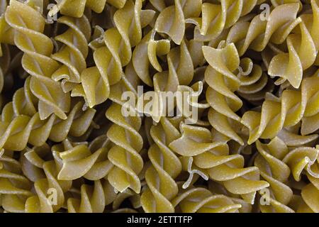 Nahansicht von ungekochten spiralförmigen grünen Erbsenfusilli. Stockfoto