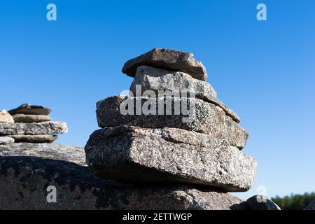 Weitblick auf zwei kleine Felsstapel auf einem Felsbrocken im frühen Morgenlicht. Stockfoto