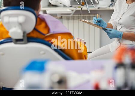 Erwachsener, der eine Aufzeichnung männlicher Wörter auf der Zwischenablage-Seite macht Stockfoto