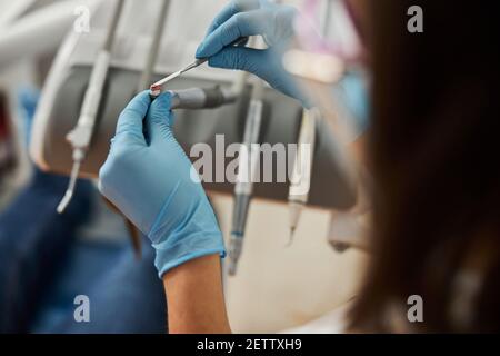 Zahnarzt schmieren Prophy Paste auf Handstück mit zahnmedizinischen Instrument Stockfoto