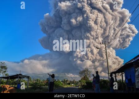 Nord-Sumatra, Indonesien. März 2021, 2nd. Am 2. März 2021 beobachten die Menschen, wie vulkanisches Material vom Berg Sinabung in Karo, Nordsumatra, Indonesien, ausgespuckt wird. Der Berg Sinabung auf der indonesischen Insel Sumatra brach am Dienstag aus und spuckte Aschewolken bis zu 5.000 Meter in den Himmel. Es gab keine Berichte über Verletzte oder Schäden. Kredit: Sarianto Sembriing/Xinhua/Alamy Live Nachrichten Stockfoto