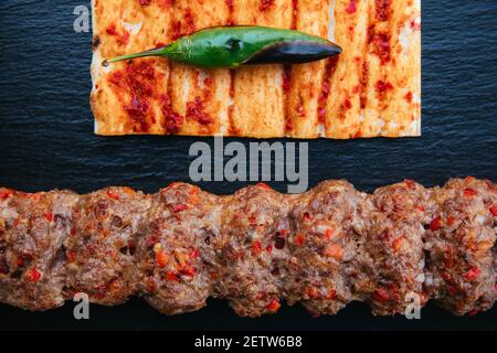 Traditioneller türkischer gegrillter Shishkebab oder Kebap. Köstlicher Adana Kebab auf schwarzem Hintergrund. Stockfoto