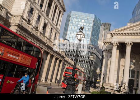 Wenige Tage bevor der Kanzler Rishi Sunak sein Budget abgibt, stehen Busse an roten Ampeln mit einem weiten Blick auf die Bank of England (links) und Royal Exchange (rechts) in der City of London, dem Finanzviertel der Hauptstadt, am 1st. März 2021 in London, England. Stockfoto