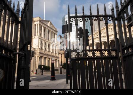 Wenige Tage bevor der Kanzler Rishi Sunak sein Budget abgibt, sieht man durch die halb geöffneten Tore eines Eingangs zur U-Bahn-Station Bank in der City of London, dem Finanzviertel der Hauptstadt, einen weiten Blick auf die Bank of England und die Statue eines berittenen Herzogs von Wellington. Am 1st. März 2021 in London, England. Stockfoto