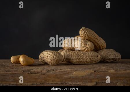 Erdnuss in einer Schale auf Holzhintergrund. Hintergrund für das Essen. Stockfoto
