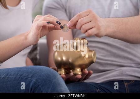 Paar spart Geld mit Sparschwein Stockfoto