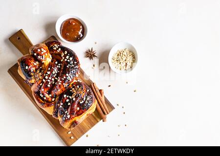 Babka oder Brioche Brot mit Aprikosenmarmelade und Nüssen. Hausgemachtes Gebäck zum Frühstück. Konkreter Hintergrund. Selektiver Fokus. Stockfoto