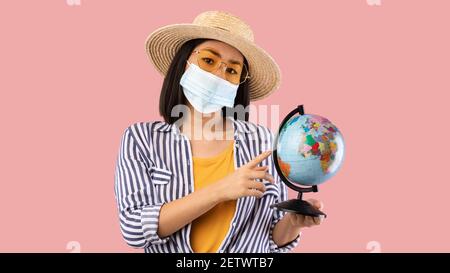 Traurige Asiatische Frau Hält Globe, Trägt Gesichtsmaske Stockfoto