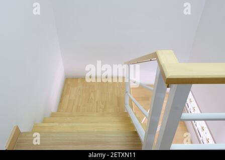 Moderne geschwungene Holztreppe mit dem weißen Metallhandlauf im Stadthaus, sauber und hygienisch von der Haushälterin, oben mit dem Kopierraum Stockfoto