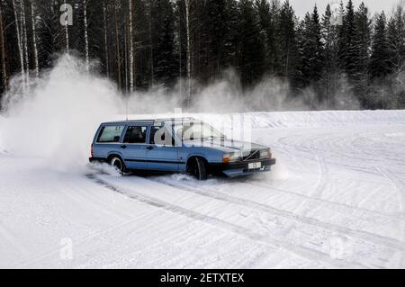 Ein Polizeifahrzeug dreht sich in eine breite Wendung auf einer Rutschwanne und sendet Schneesprühen in seine Spur. Es ist Teil des Schneetrainings für den finnischen Traffi Stockfoto