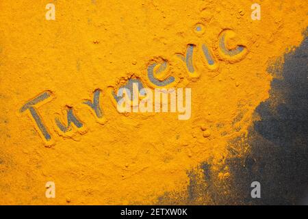 Frau Handpudering indischen Gewürzen Kurkuma Pulver Spritzer Explosion Stein Mörser Kerala Indien Sri Lanka traditionelle indische Küche Masala für Curry Stockfoto