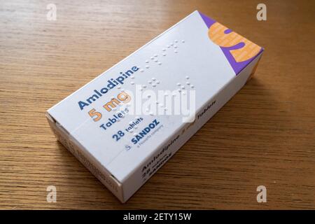 Eine Detailansicht einer Schachtel mit 5mg Amlodipin, hergestellt von der pharmazeutischen Firma Sandoz, Novartis, am 1st. März 2021 in London, England. Amlodipin ist bekannt als Calcium Blocker zur Reduzierung der Hypertonie (Bluthochdruck). Stockfoto