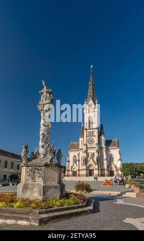 Kirche des heiligen Herzens, 1894, neugotischer Stil, Säule der Heiligen Dreifaltigkeit (Pestsäule), 1713, auf dem Fo Ter (Hauptplatz) in Koszeg, Ungarn Stockfoto