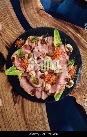 Rind- oder Schweinefleisch in Scheiben geschnitten mit mariniertem Gemüse und Sauce. Wunderschön dekoriertes Catering-Bankett-Menü. Essen Snacks und Vorspeisen für Buffet. Auf weiß Stockfoto