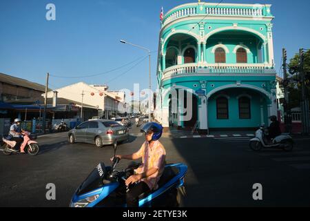 Motorradfahrer passieren ein Wahrzeichen chinesisch-portugiesischen Gebäude an der Ecke Yaowarat Rd / Dibuk Rd in der Altstadt (Chinatown) Bereich von Phuket Town, Thailand Stockfoto